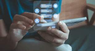 Gérant utilisant un smartphone pour répondre aux messages de ses clients en ligne.